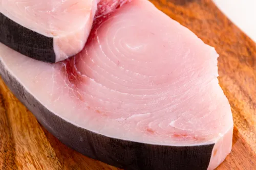 Fresh swordfish steak on a wooden cutting board