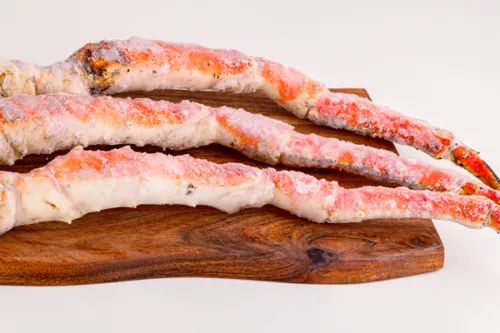 Alaskan king crab legs arranged on a wooden board